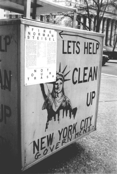 Photo of a garbage can holder.  The holder has a picture
of the Statue of Liberty.  The text on the holder says "Lets Help Clean Up New York City" to which I added the word "Government" by using a marker.  I then took the sticker and stuck it in the place of the
Statue of Liberty's torch.  CLASSIC!  Too bad you can't see it!